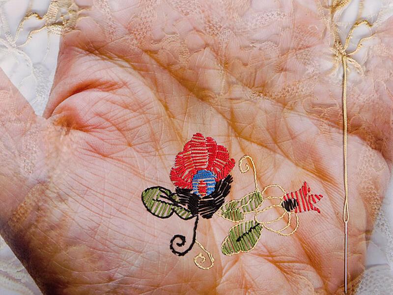 Photograph of a hand with flower embroidered on it