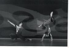 Cecilia Baram dancing, standing on her hands with her legs held in a lunging position, as Miguel Angel Palmeros lunges beside her