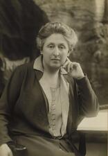 Cécile Brunschvicg sitting at a desk, with her elbow resting on an open book