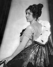 Over-the-shoulder portrait of Fritzi Massary, wearing an ermine-trimmed cape, a lace dress, and jewels