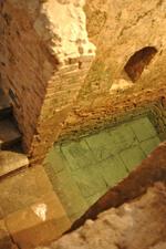 Steps leading down into a worn stone mikveh