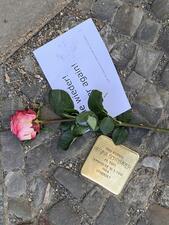 Berlin "Stumbling Stone" to commemorate Holocaust victim with rose and sign reading "never again" placed on top