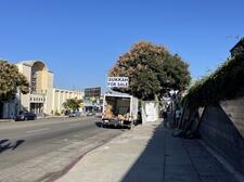 Street scene including truck with "Sukkah for Sale" sign