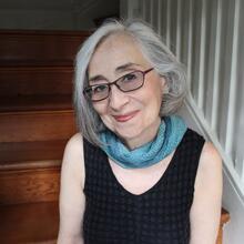 Portrait of Marcia Falk sitting on a staircase