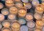 About 30 lit yahrzeit candles on the ground