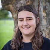 Photo of Ellanora Lerner, in front of a tree wearing a dark blue hoodie.