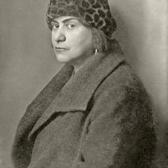 Studio portrait of Else Lasker-Schüler, wearing a coat and a leopard-print hat