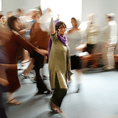 Judith Brin Ingber in focus leading dance at a Minnesota bat mitzvah party reception, others in motion around her