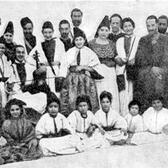 About two dozen adults and children pose for a group photo.