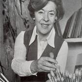 Judy Cassab reaching for a paintbrush