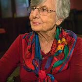 Ruth Brondy looking off camera, wearing a colorful scarf