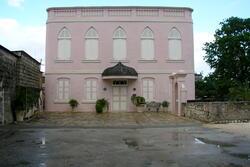 A two-story pink building with white accents