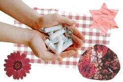 Collage of hands holding tampons on red and white background 