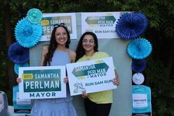 Two people holding signs that read "Vote Samantha Perlman"