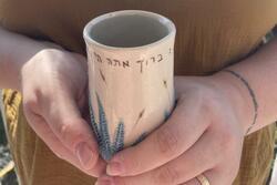 Close up of hands holding Miriam's Cup