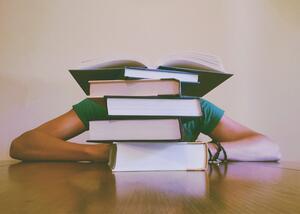 Student Sitting Behind Books