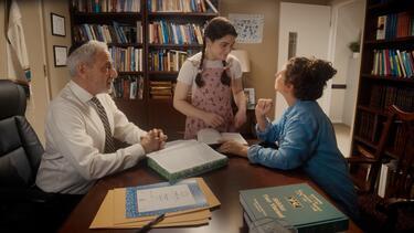 Photo of a teenager girl talking to her mother and a rabbi in the rabbi's office