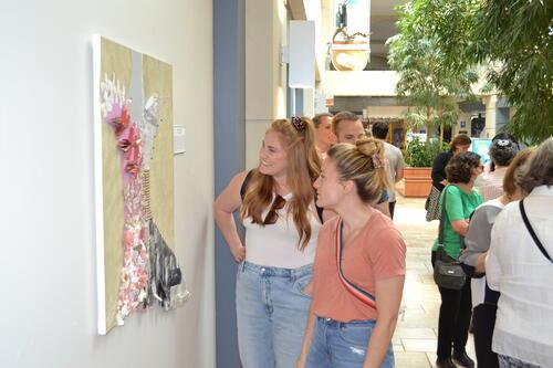 Jaime Stepansky and friend view her art piece, "Becoming," at Artful Disclosure Exhibition