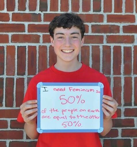 Boy Holding Femininjas Sign