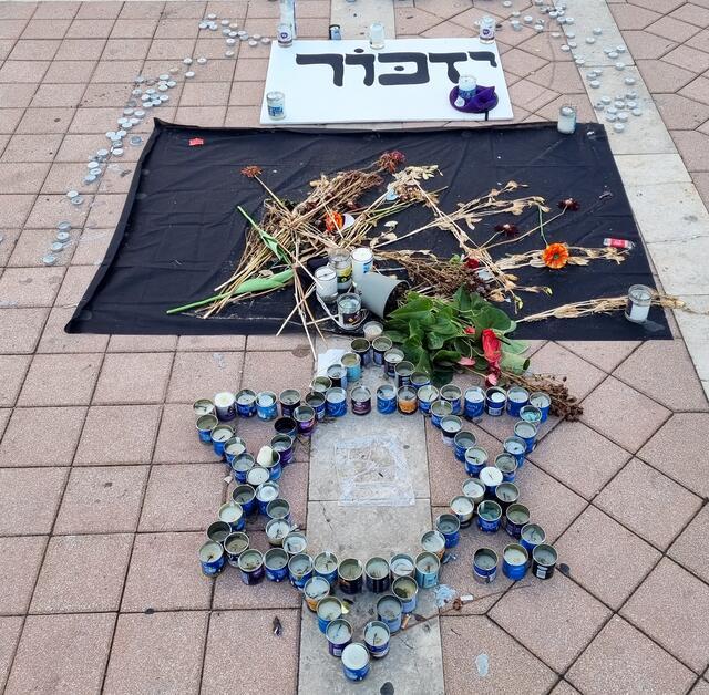 Candles and Yizkor sign remembering Oct 7