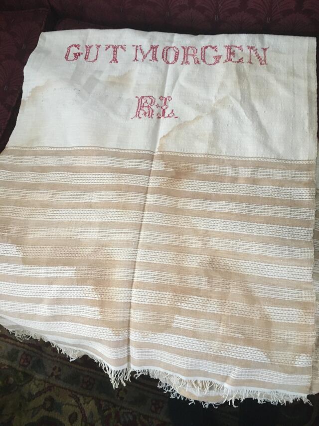 A white cloth with the words "Gut Morgen" (Good Morning in Yiddish) followed by the initials R.L.