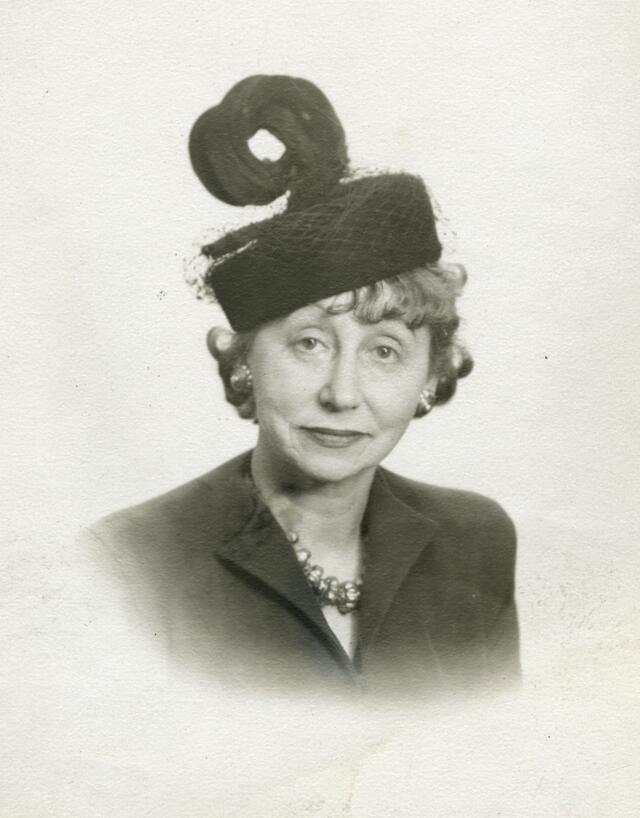 A portrait of Adeline Schulberg wearing a black hat