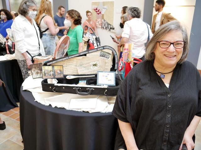 Judy Robkin with her art piece, "Unfinished Symphony"